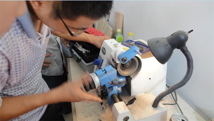 亲自示范教学员如何打磨雕刻刀